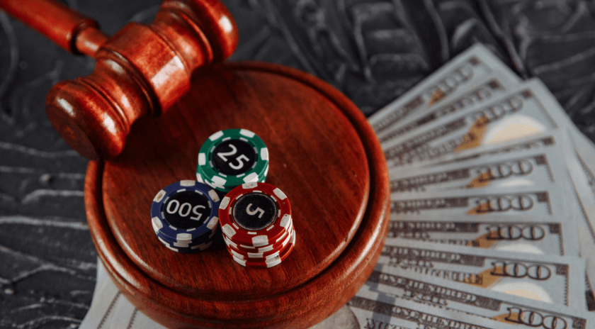 a gavel and casino chips sit on top of cash